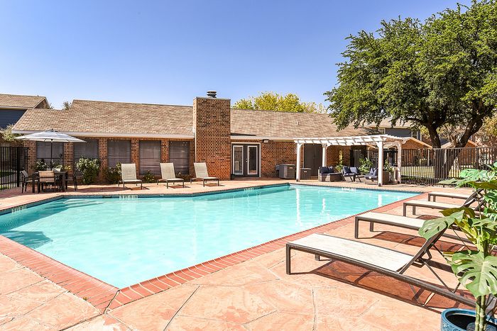 Inviting outdoor swimming pool area with sun loungers and shaded seating, perfect for relaxation and leisure.