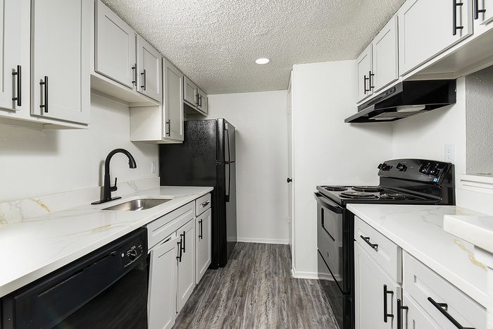 Sleek modern kitchen with stainless steel appliances, white cabinetry, and elegant marble countertops.