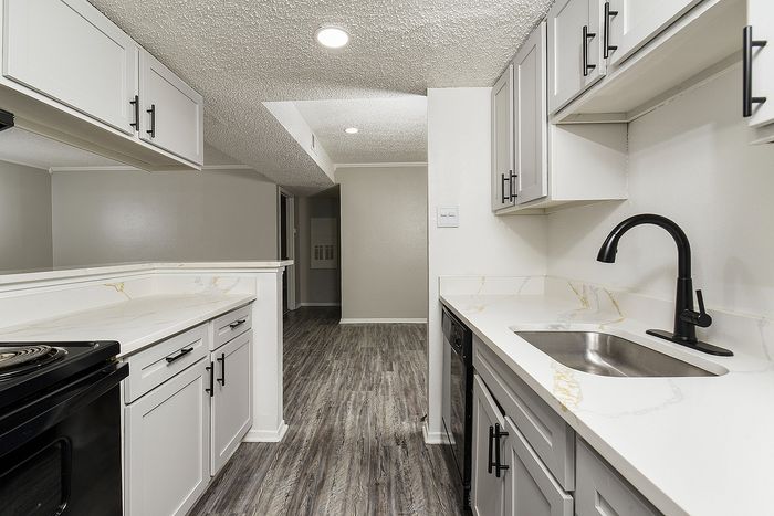 Modern kitchen featuring sleek cabinetry, marble countertops, and stylish fixtures with elegant flooring.