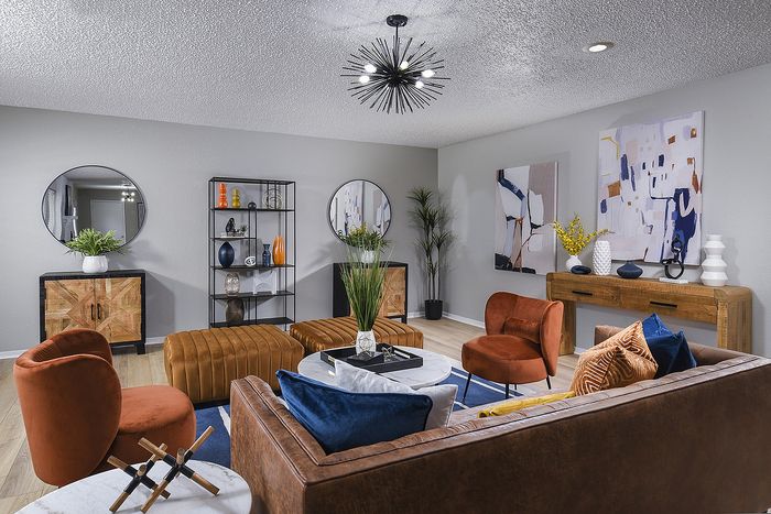 Chic living room with modern d&eacute;cor, featuring plush seating, stylish art pieces, and ambient lighting for a cozy atmosphere.