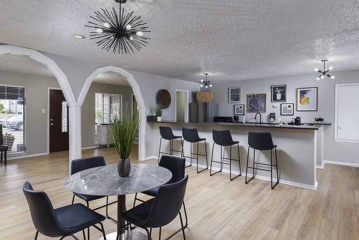 Chic open-concept living area featuring a modern breakfast bar, stylish pendant lighting, and elegant wooden flooring.