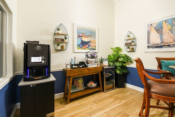 Charming corner space featuring a cozy coffee bar with modern decor and vibrant artwork, perfect for relaxation.