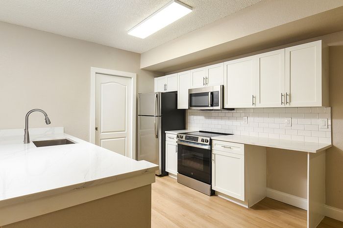 Modern kitchen with sleek stainless steel appliances, elegant white cabinetry, and chic subway tile backsplash.