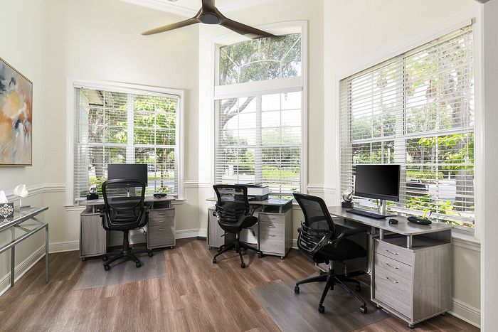 Bright and modern home office with stylish desks, ergonomic chairs, and large windows for abundant natural light.