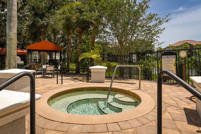 Inviting outdoor jacuzzi area surrounded by lush greenery, featuring elegant seating under a stylish gazebo for ultimate relaxation.