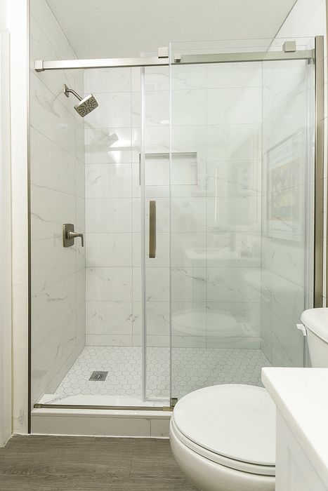 Modern bathroom featuring a sleek glass shower enclosure with elegant tiles and contemporary fixtures.