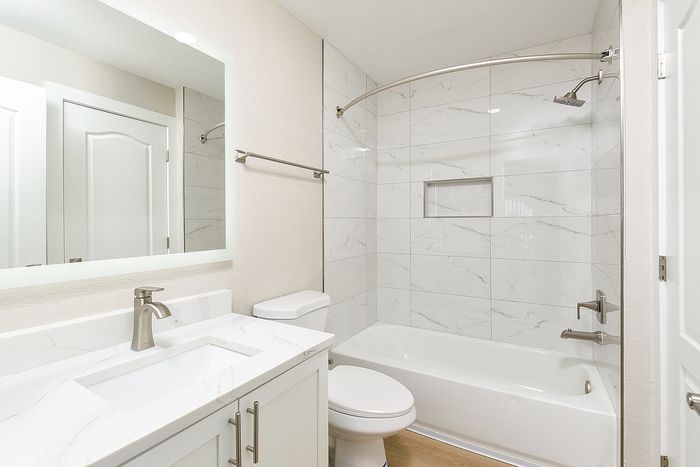 Modern bathroom with elegant marble tiles, sleek fixtures, and a spacious bathtub.