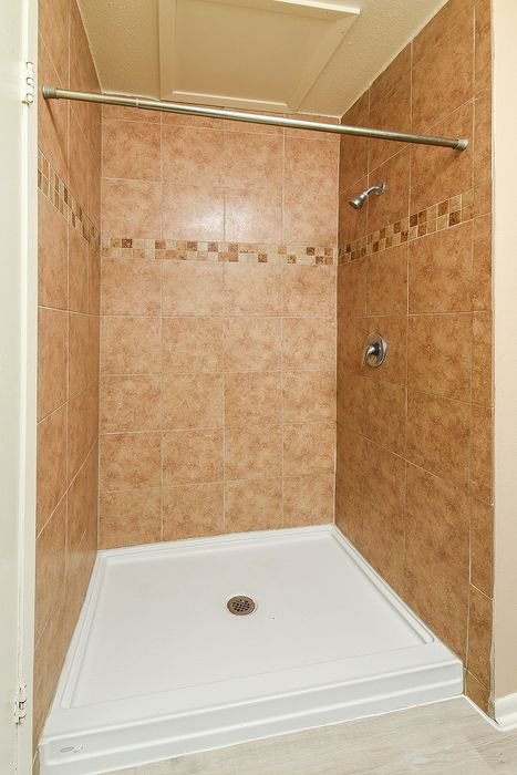 Elegant shower area with stylish beige tiles and modern fixtures, offering a clean and sophisticated look.