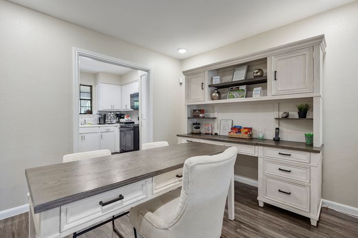 Charming dining area leading to a modern kitchen, featuring elegant white cabinetry, ideal for both entertaining and everyday living.