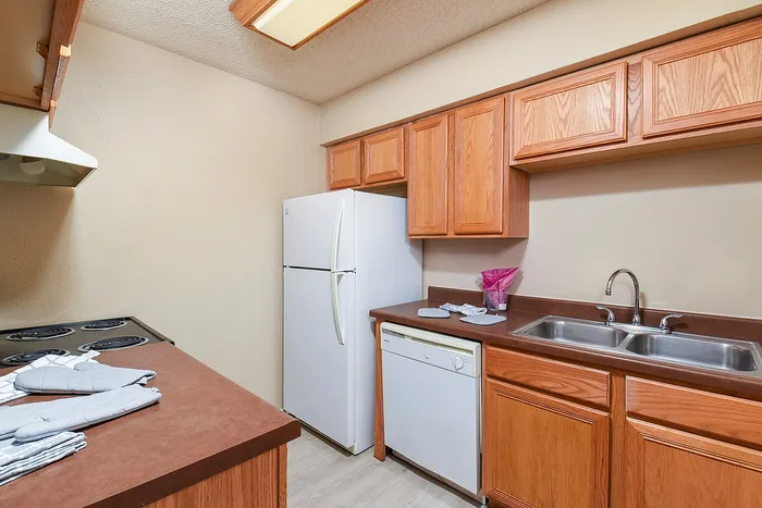 Charming kitchen with ample wooden cabinetry, modern appliances, and a sleek double sink, perfect for culinary enthusiasts.