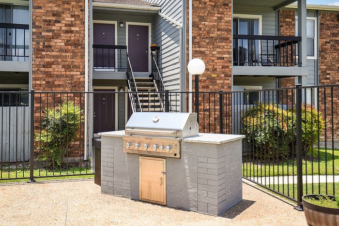 Charming apartment exterior with a modern built-in BBQ grill, perfect for outdoor entertaining.