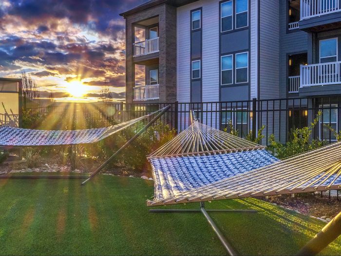 Relaxing area with hammocks near residential buildings at Solis City Park apartments for rent
