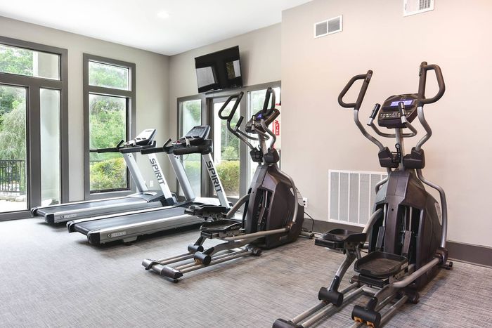 Fitness center with cardio equipment and free weights at Pointe at Canyon Ridge apartments for rent in Atlanta, GA