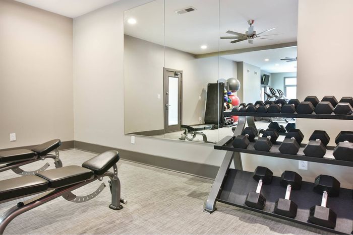 Fitness center with cardio equipment and free weights at Pointe at Canyon Ridge apartments for rent in Atlanta, GA