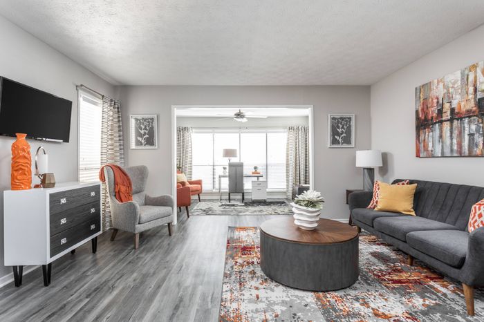 Furnished vast living room with ample seating, ceiling fan, and windows for natural light at Pointe at Canyon Ridge apartments for rent in Atlanta, GA