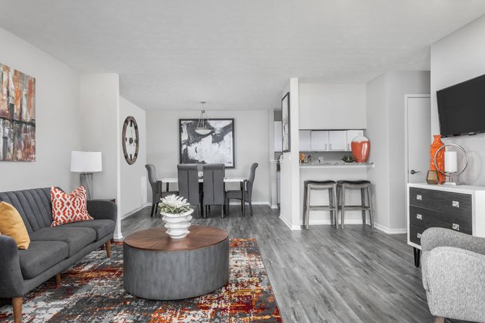 Furnished open-concept living room with ample seating and view of dining area at Pointe at Canyon Ridge apartments for rent in Atlanta, GA