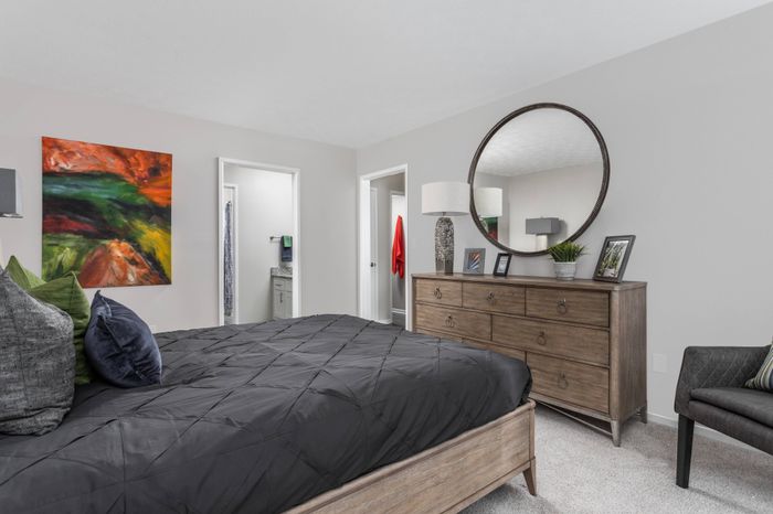 Furnished bedroom with in-suite bathroom and large walk-in closet at Pointe at Canyon Ridge apartments for rent in Atlanta, GA