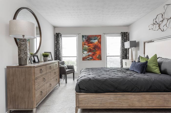 Furnished spacious bedroom with windows for natural light at Pointe at Canyon Ridge apartments for rent in Atlanta, GA