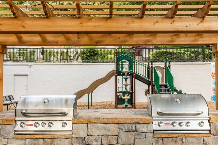 Outdoor picnic area with charcoal grills at Pointe at Canyon Ridge apartments for rent in Atlanta, GA