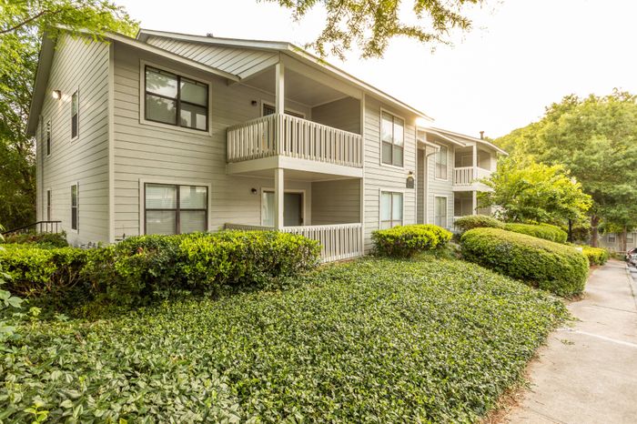 Exterior of residential buildings with balcony and patio views at Pointe at Canyon Ridge apartments for rent