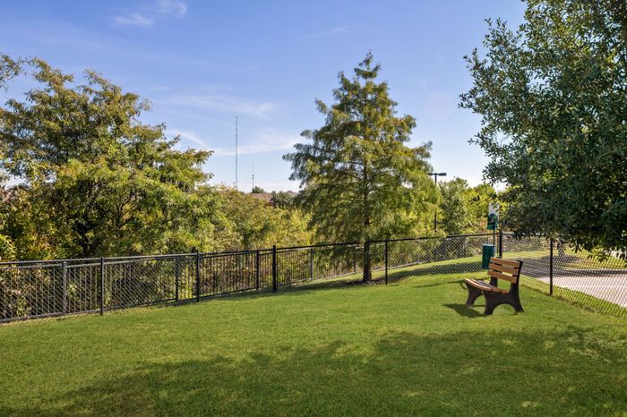 Private fenced-in off-leash dog park with bench at Avenues at Craig Ranch apartments for rent