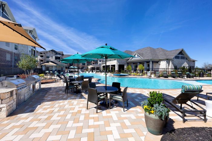 Outdoor grill and picnic area near pool at The Adley Craig Ranch apartments for rent