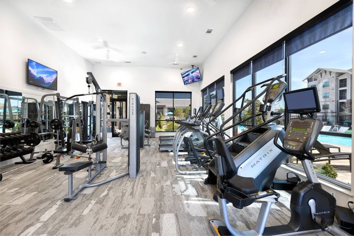 24-hour fitness center with cardio and training equipment at The Adley Craig Ranch apartments for rent