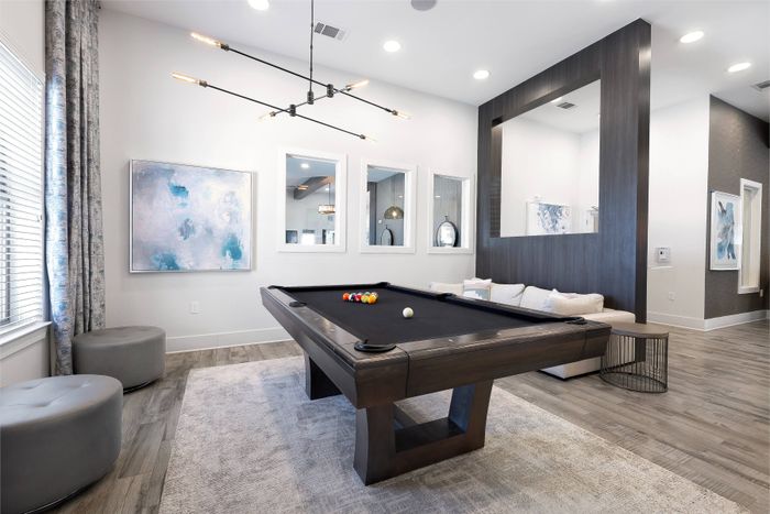 Community clubhouse with pool table in game room at The Adley Craig Ranch apartments for rent
