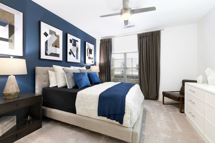 Spacious bedroom with ceiling fan and large bay window at The Adley Craig Ranch apartments for rent in McKinney, TX