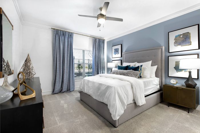 Bedroom with ceiling fan and large bay window at The Adley Craig Ranch apartments for rent