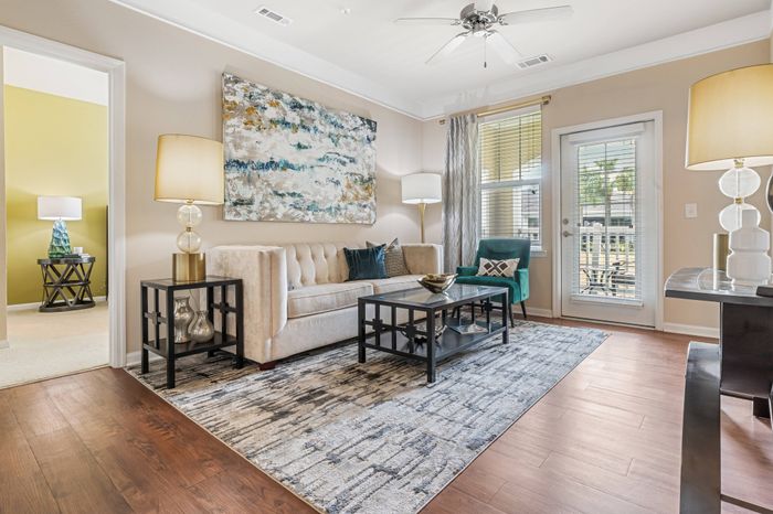 Bright living room with ample seating, ceiling fan, and lofty 9-ft. ceilings at St. James at Goose Creek apartments for rent