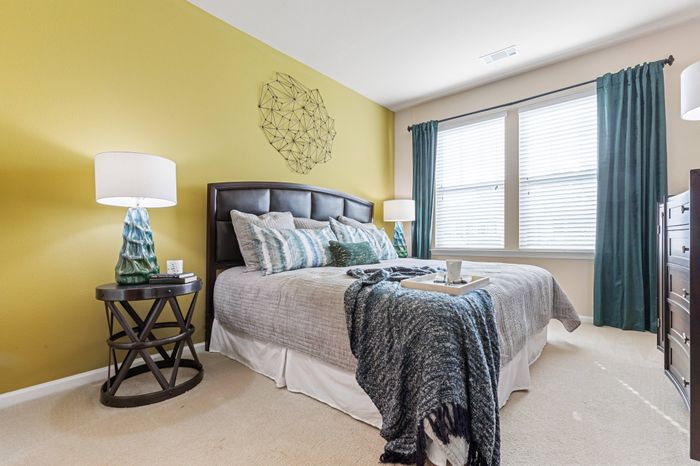 Furnished master bedroom with en-suite bathroom at St. James at Goose Creek apartments for rent in Charleston, SC