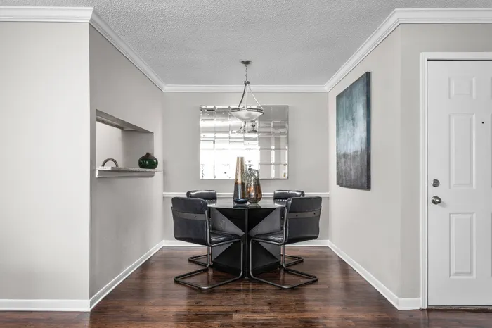 Opening dining room with hardwood flooring and pass-through window to kitchen