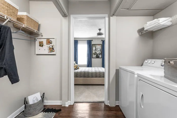 Huge apartment laundry room with storage space, shelving, and in-unit, full-size washer and dryer
