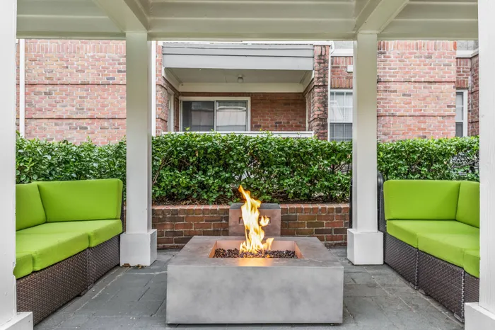 Covered sitting area with cozy seating and fire pit at apartments for rent in Memphis