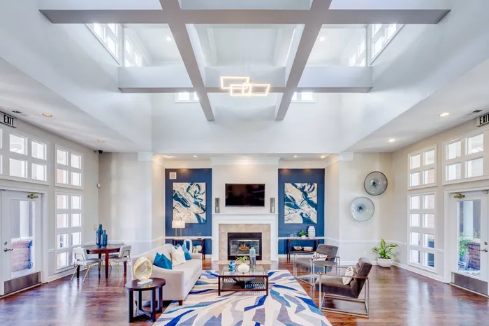 Spacious apartment clubhouse with high ceilings, seating, and tv