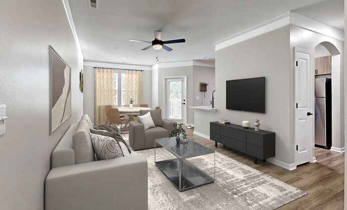 Bright living room with ample seating, ceiling fan, and lofty 9-ft. ceilings at St. James at Goose Creek apartments for rent
