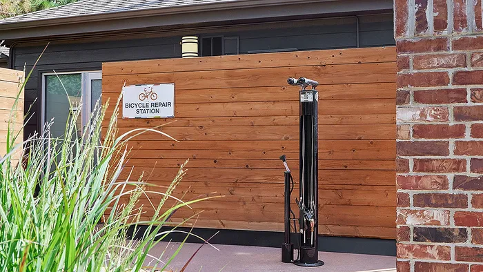 Inviting outdoor bicycle repair station with modern tools and wooden privacy fence, perfect for active residents.