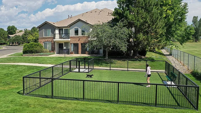 Charming apartment complex with lush greenery and a secure dog park, perfect for pet-friendly living.
