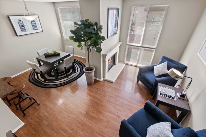Chic living area with elegant dining set, cozy fireplace, and abundant natural light from large windows.