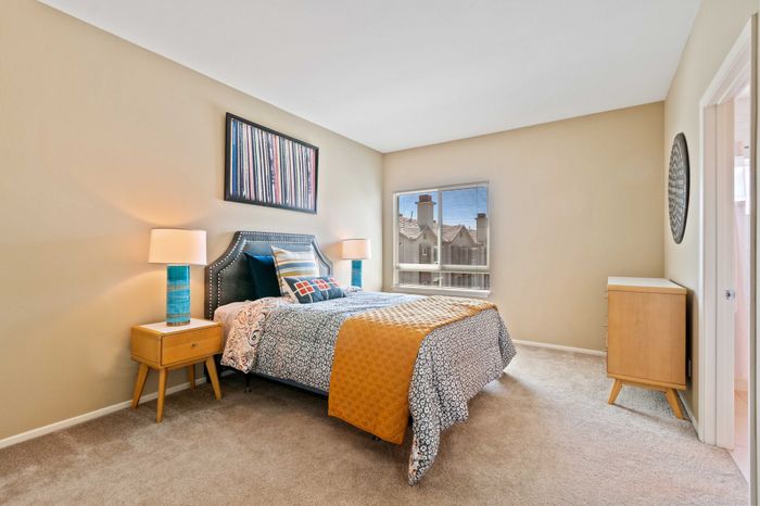 Bright and inviting bedroom with modern decor, featuring a plush bed, stylish side tables, and a large window offering beautiful views.