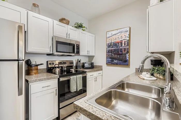 Chic modern kitchen with white cabinets, granite countertops, and stainless steel appliances, perfect for gourmet cooking.