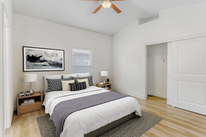 Bright and airy bedroom with modern decor, featuring a cozy bed, elegant side tables, and a spacious closet.