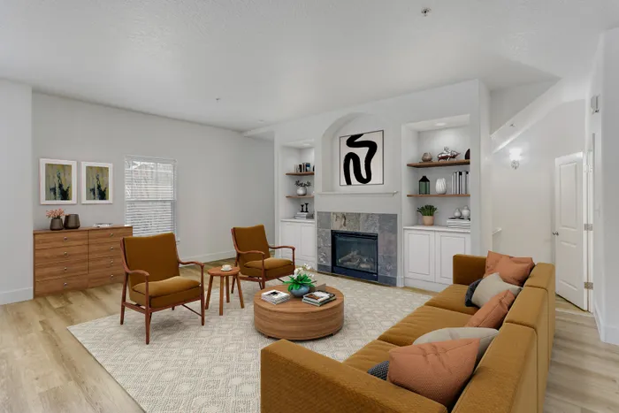 Charming living room with contemporary decor, featuring a stylish fireplace, cozy seating area, and elegant shelving for a sophisticated ambiance.