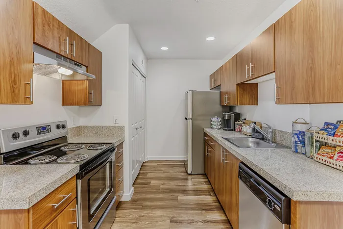 Modern kitchen featuring sleek stainless steel appliances, elegant wooden cabinetry, and polished granite countertops.