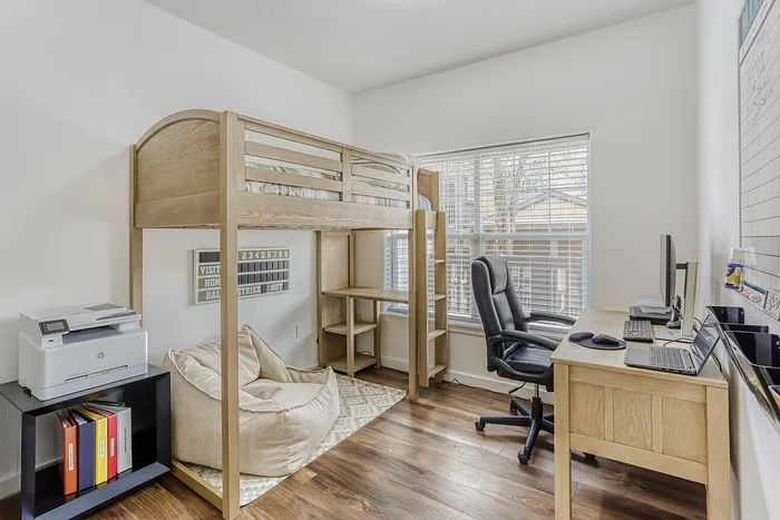 Bright and airy home office with a versatile loft bed, ergonomic chair, and spacious desk setup.