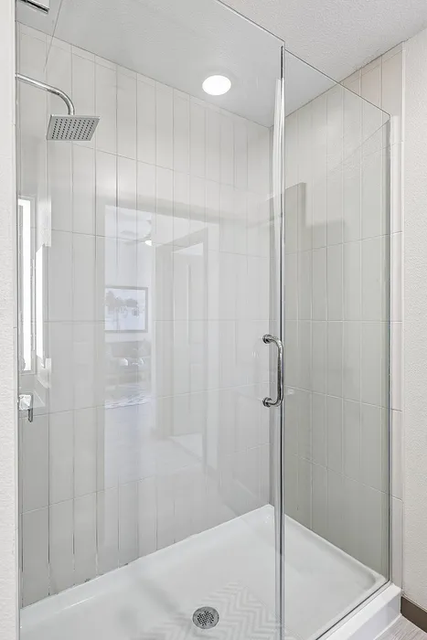Elegant bathroom with a modern glass shower enclosure and sleek tile walls.