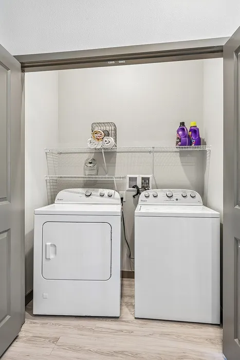 Modern laundry area featuring energy-efficient washer and dryer with ample shelving for storage and organization.