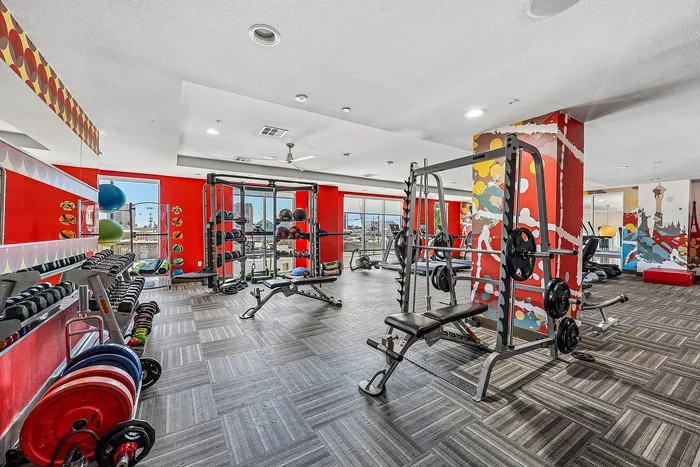 Vibrant fitness center featuring modern exercise equipment, colorful decor, and expansive city views.