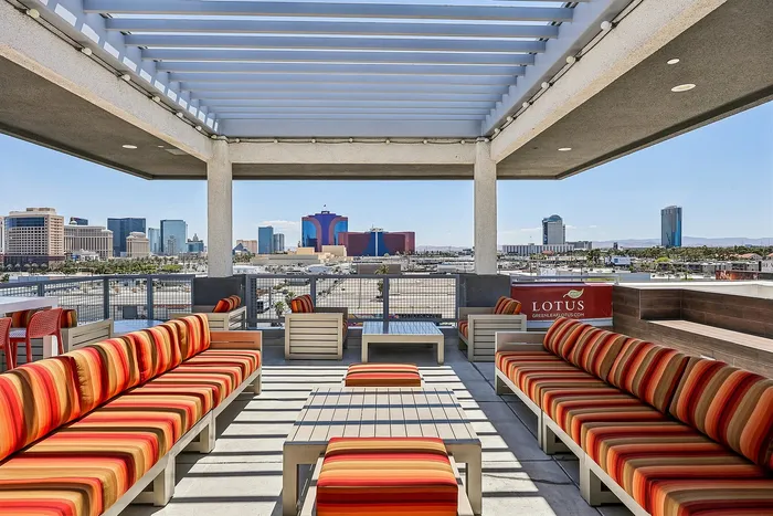 Chic rooftop lounge with colorful seating offering panoramic views of the vibrant city skyline.